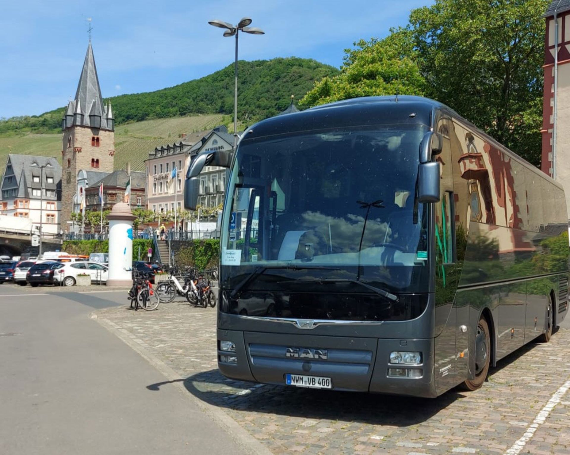 Ein Bus steht geparkt auf der Straße, umgeben von Bürgersteig und Gebäuden.