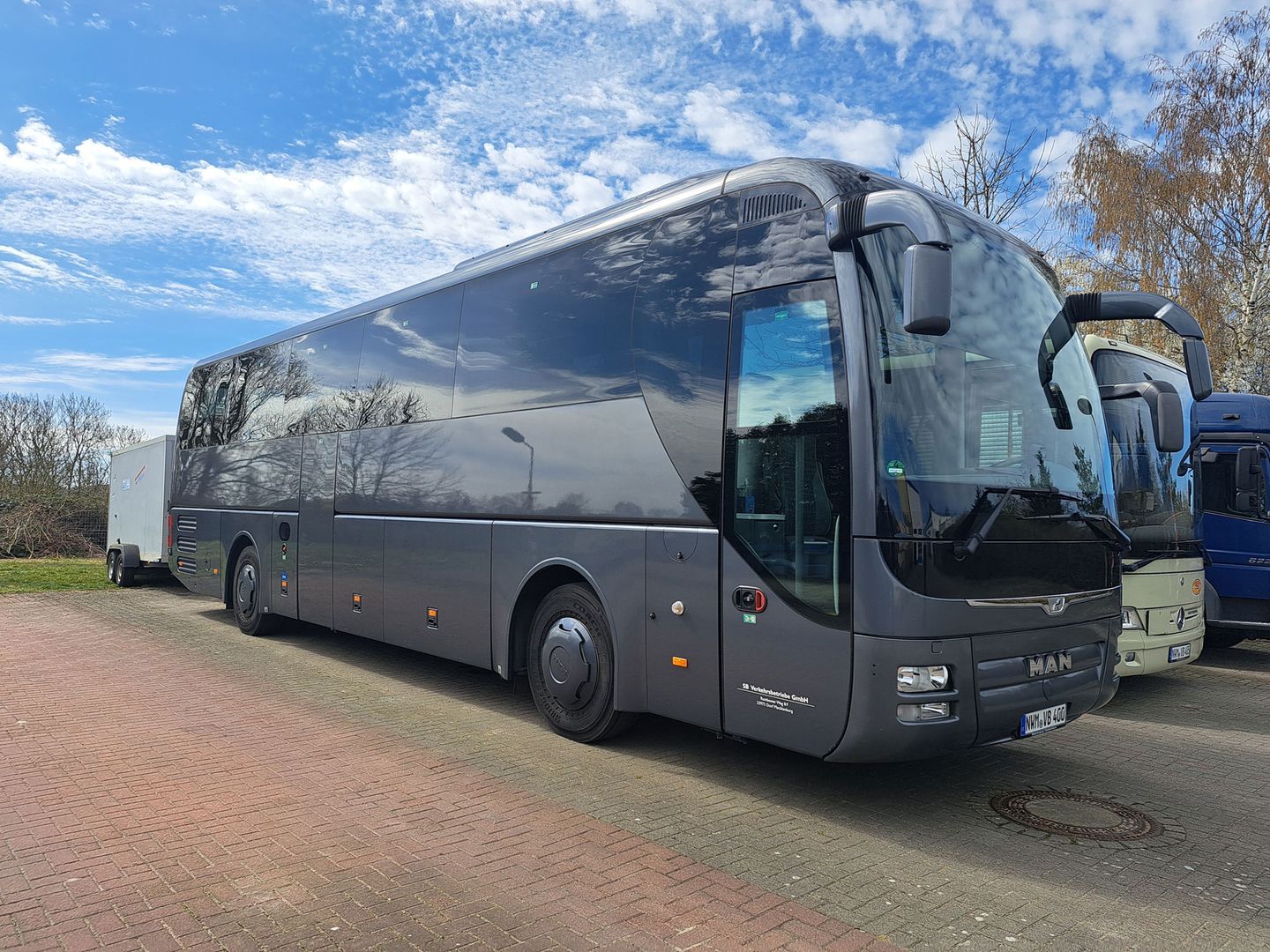 Ein schwarzer Reisebus parkt auf der Straße, ideal für Busreisen.